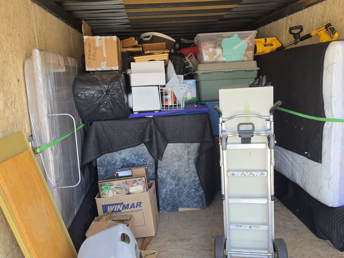 TCM Movers trailer loaded and strapped with furniture, boxes and a hand truck